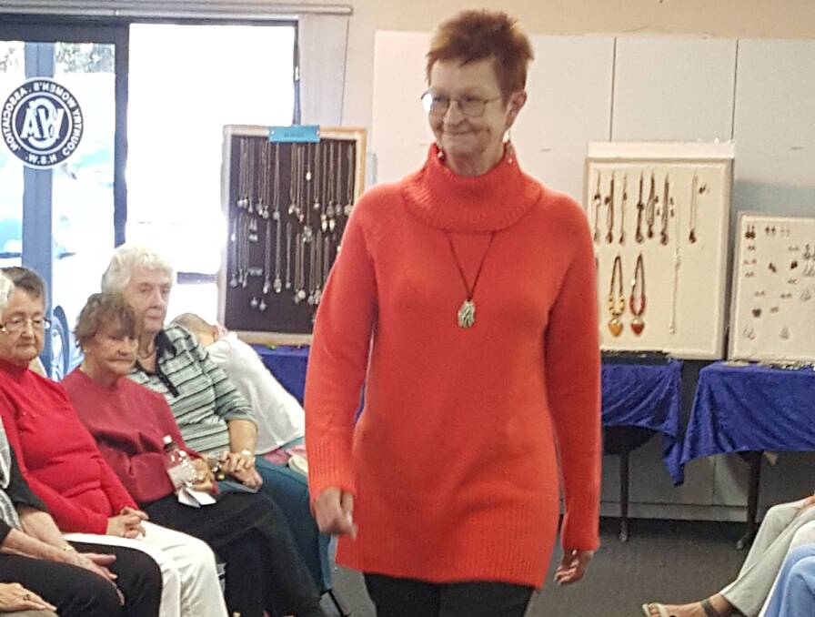 Helen Clifton models a vibrant orange jumper with a polo neck and black stretch pants at the Sunshine Bay parade.