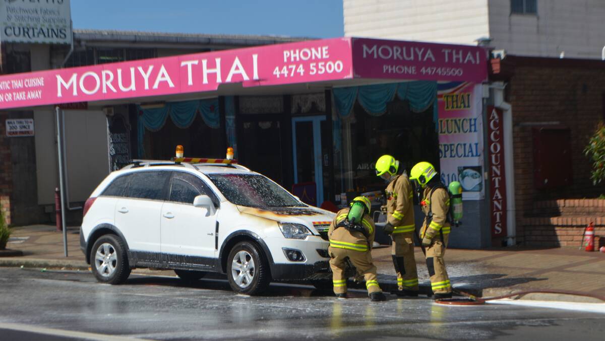Moruya Fire and Rescue firefighters extinguish the car fire in Moruya on Friday.