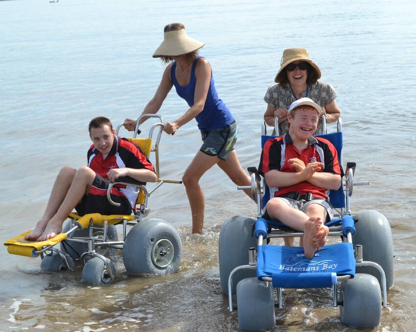 WATER WHEELS: The Batemans Bay High school staff and students try the new beach chairs in the water.