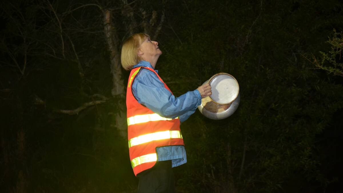 A volunteer bangs pots and pans on Tuesday morning at Heron Road. 