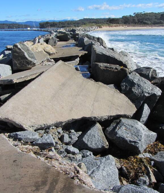 DAMAGED: Large swell during the June storm made a mess of the Moruya breakwall, smashing concrete and washing large boulders onto the pathway. Photo: Sue Wallensky 