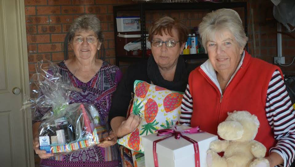 GOOD CAUSE: Batemans Bay Hospital Auxiliary's Jeannette Sinclair, Ann McClintock, and Madge Elliott with some of the items up for auction at their June 24 Charity Auction.