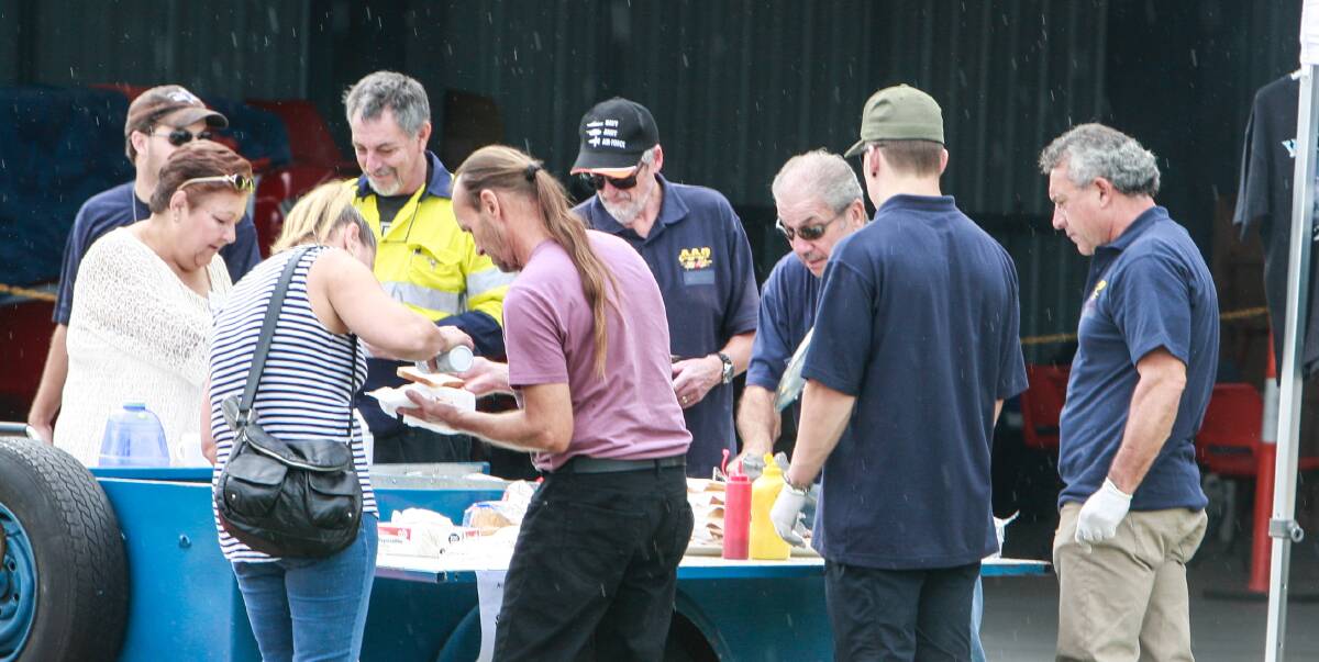 Aerial patrol general manager Harry Mitchell (third from right) is among those lending a hand at a fundraiser barbecue for the not-for-profit service at the weekend. Picture: Georgia Matts