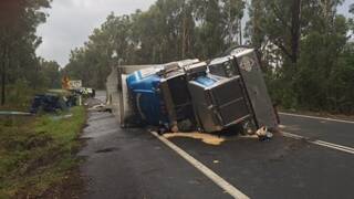 Emergency services work on a semi trailer that rolled on the Princes Highway south of Sussex Inlet.