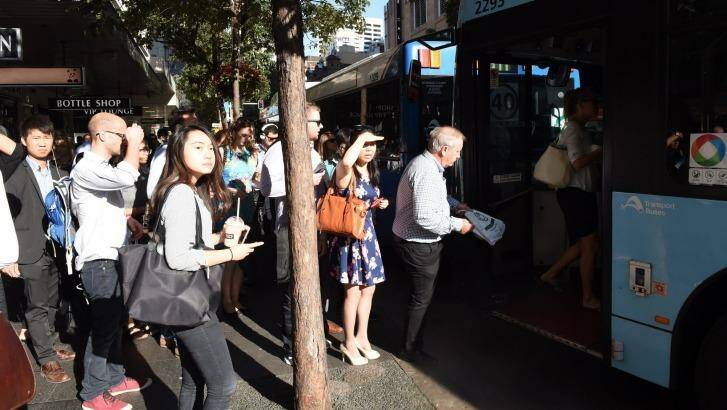 Commuters board a bus  at the Park and Elizabeth streets corner, which is said to have improved under the changes.  Photo: Nick Moir
