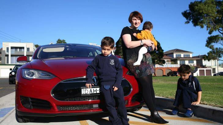"I feel less guilty about driving": Belinda Sundaraj with her children and the family's electric car. Photo: Louise Kennerley