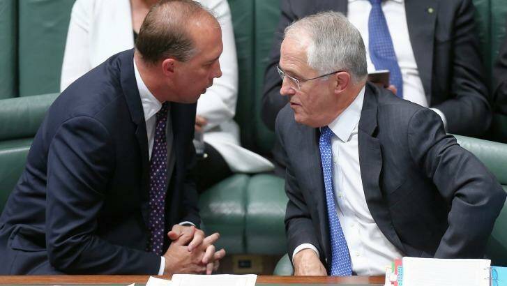 Immigration Minister Peter Dutton and Prime Minister Malcolm Turnbull confer during question time. Photo: Alex Ellinghausen