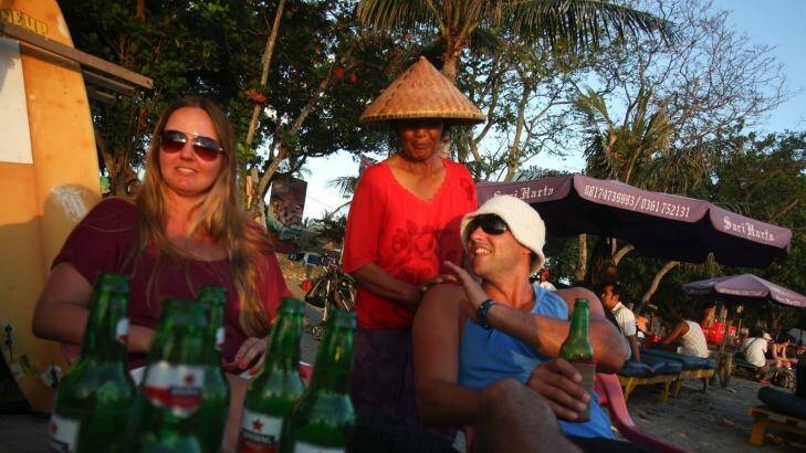 An Australian couple drinks beer while watching the sunset at Legian Beach in Bali. Photo: RAHMAN ROSLAN