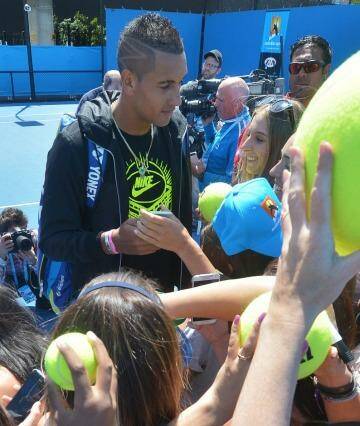 Nick Kyrgios signs autographs after his practice session on Monday. Photo: Joe Armao