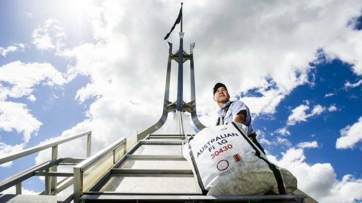 Flagged:
Parliament House Maintenance Officer Jason Carew with a replacement flag in the three-man lift used to ascend the flag pole.