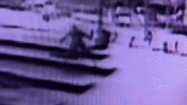 Security footage shows a man throwing rocks at the Lindt cafe in Martin Place. Photo: Channel Nine