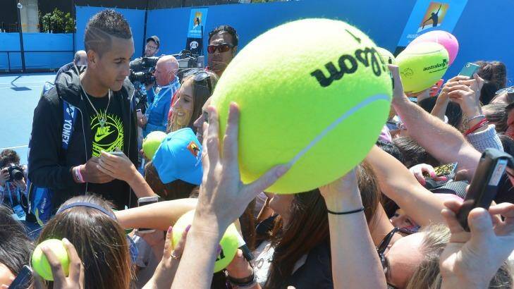 Nick Kyrgios signs autographs after his practice session on Monday. Photo: Joe Armao