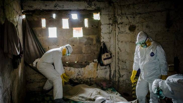 Members of an Ebola burial team collect the body of a suspected Ebola victim from a home in Monrovia, Liberia.