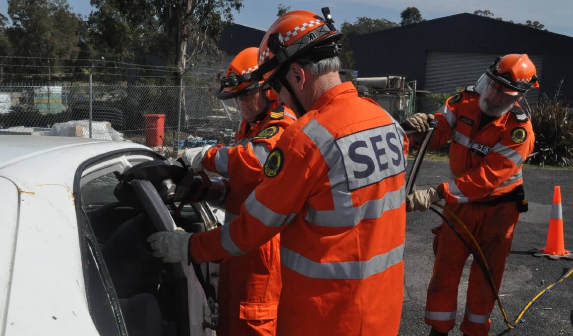 VITAL SKILLS: Moruya State Emergency Service’s Martin Ransom, Lex King and Chris Zammit use hydraulic cutters to open a practice car at the unit’s headquarters. The SES is the first call when people must be removed from vehicles at accident scenes, but Fire and Rescue NSW can also respond. 
