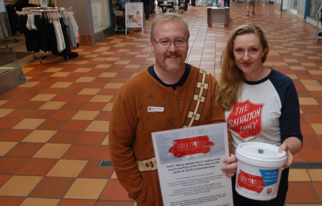 COUCH PROJECT: Batemans Bay Salvation Army commanding officers Ross and Melanie Holland hit the streets to raise awareness and funds for youth homelessness. Mr Holland had promised to wear a onesie if he got $500 in donations.
