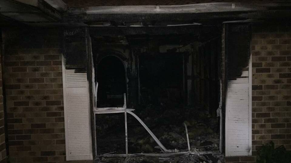 EXTENSIVE DAMAGE: A Moruya Fire and Rescue firefighter inside the house at Beach Street in Tuross Head on Saturday night.