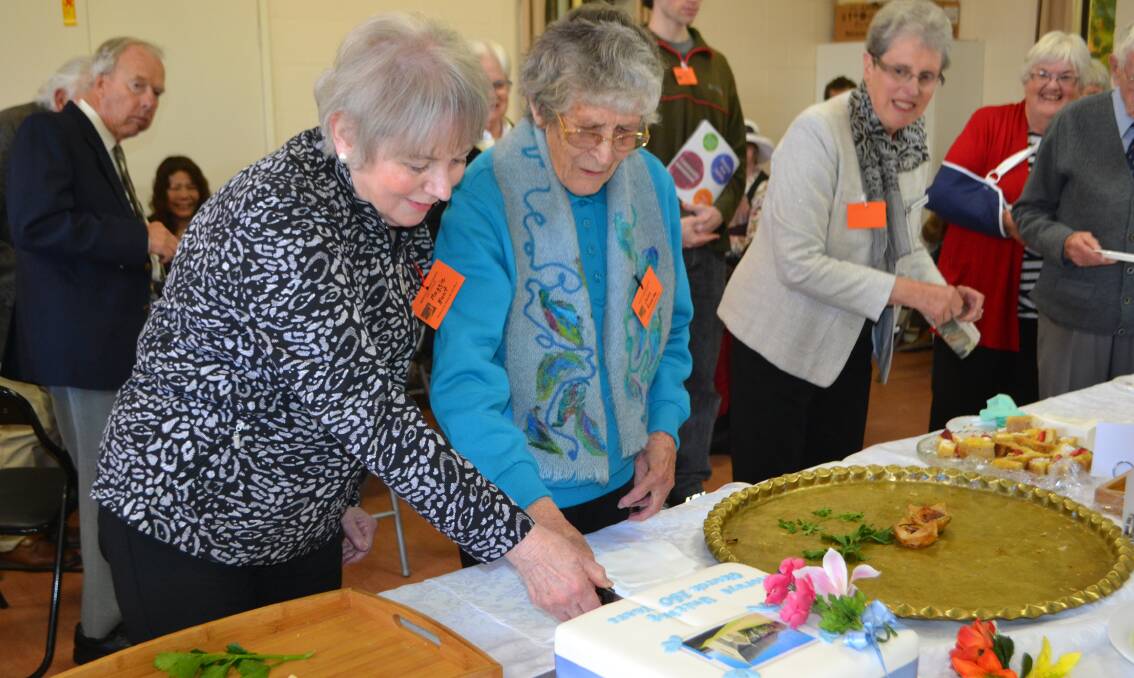 GRAND OCCASION: Maggie Hunt and Joan Rourke cut the cake at the Moruya Uniting Church 150th anniversary celebration on Sunday.