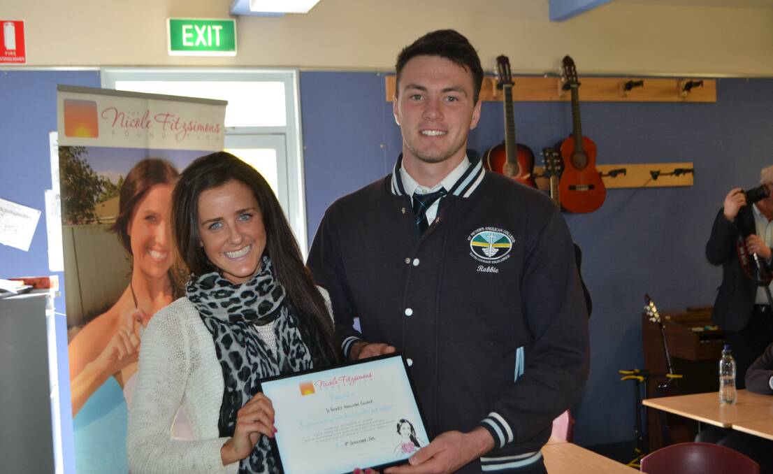 MUCH APPRECIATED: Kate Fitzsimons of the Nicole Fitzsimons Foundation presents a certificate of appreciation to St Peter’s Anglican College captain Robbie Hogg on Friday.