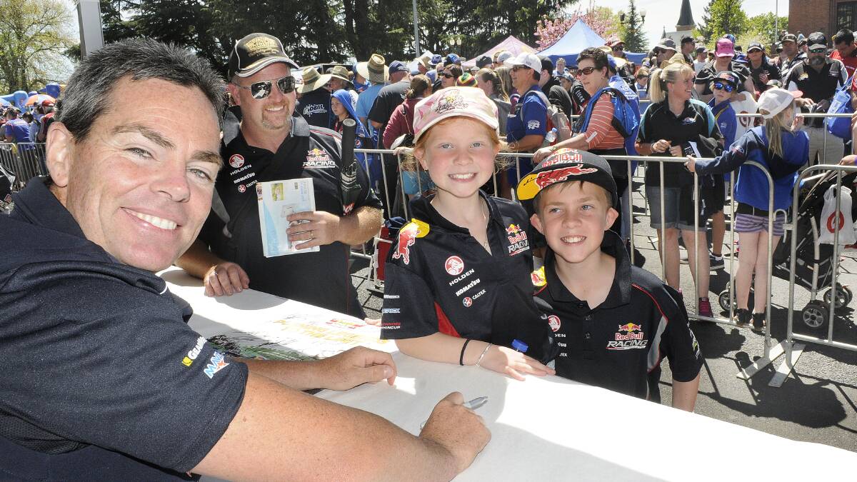 LEGEND: Brett Smith took his children, Alannah and Liam, to the Kings Parade drivers signing to meet V8 driver Craig Lowndes. Photo: CHRIS SEABROOK	 100814craig