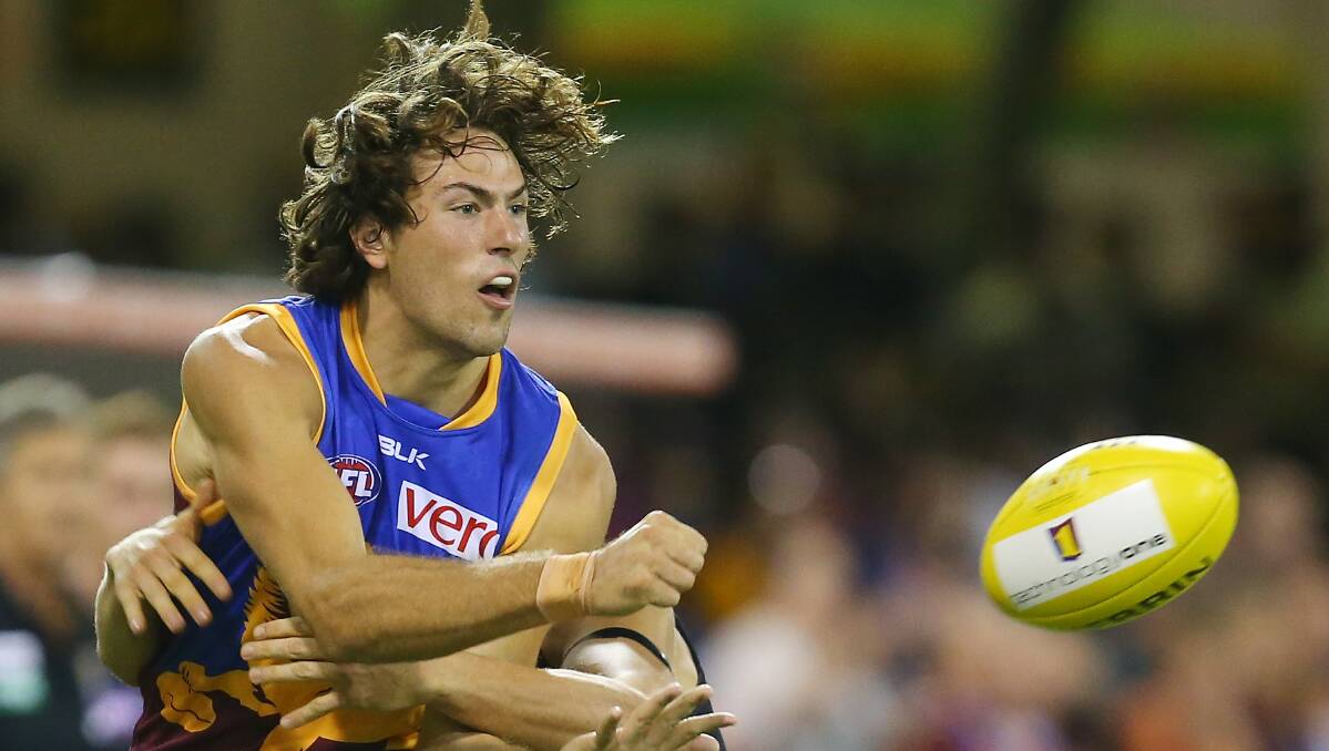 Marco Paparone of the Lions handballs during the round five AFL match between the Brisbane Lions and the Richmond Tigers at The Gabba on April 17, 2014 in Brisbane, Australia. Photo: Chris Hyde/Getty Images.
