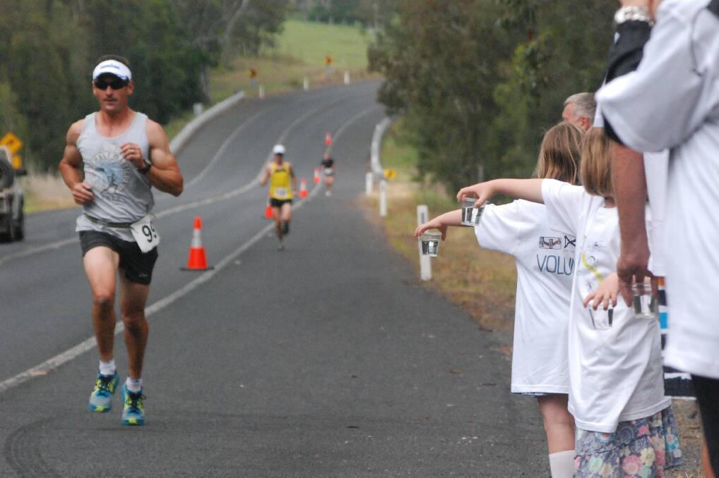 ON THE ROAD: Malua Bay’s Daniel Beby runs past a drink station on South Head Road during Sunday’s Moruya Town to Surf.