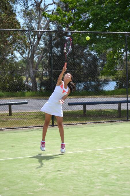 OVERHEAD SLAM: Jade Haberland returns a high bouncing lob at Moruya Tennis Club. 