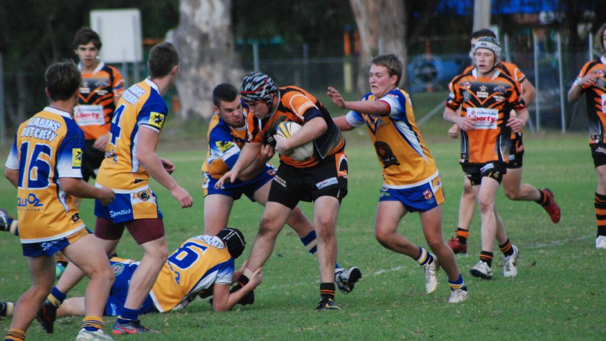 PLUGGING AWAY: Bailey Scholtz powers through three Warilla Gorillas in his sides 22-16 win at Mackay Park.