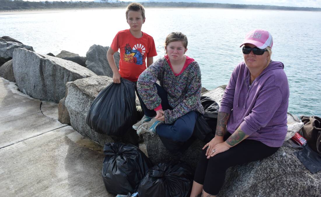 Kaleb, Tarlea and Mandi Powell have collected five bags of rubbish from the Moruya break wall over the Easter long weekend and are encouraging people to take their rubbish with them from the site.  