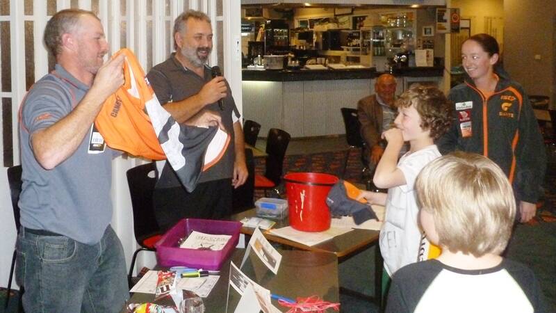PRIZE WINNER: Marty Jones hands Kobe Tuan his raffle prize, a new GWS Giants jersey, at the Moruya Bowling Club last Tuesday. 