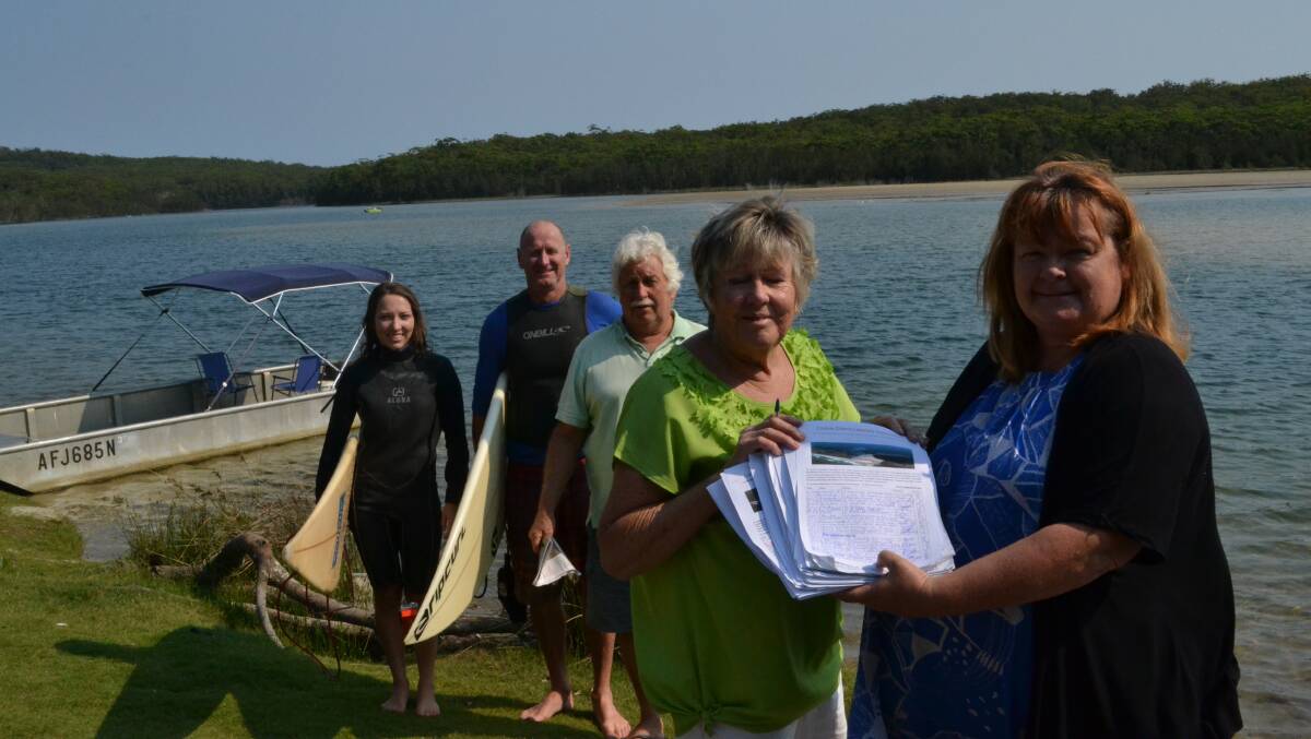 ULLADULLA: Lake Conjola residents April Dowling (left), Richard McLatchies and Lakecare environment officer Col Ashford look on as Lakecare vice president Robyn Kerves presents a petition to Shoalhaven City Councillor Patricia White calling for sand in the waterway to be dredged. 