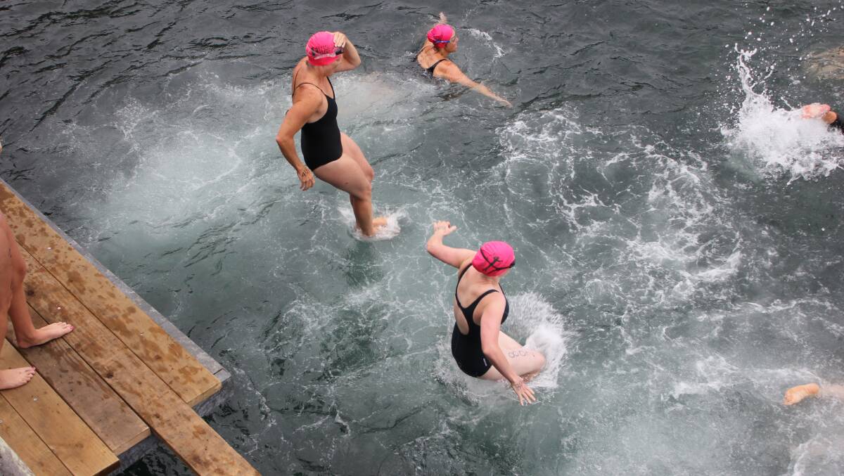 TATHRA: Competitors leap off the Tathra Wharf ahead of the Wharf to Waves Splash for Cash. 