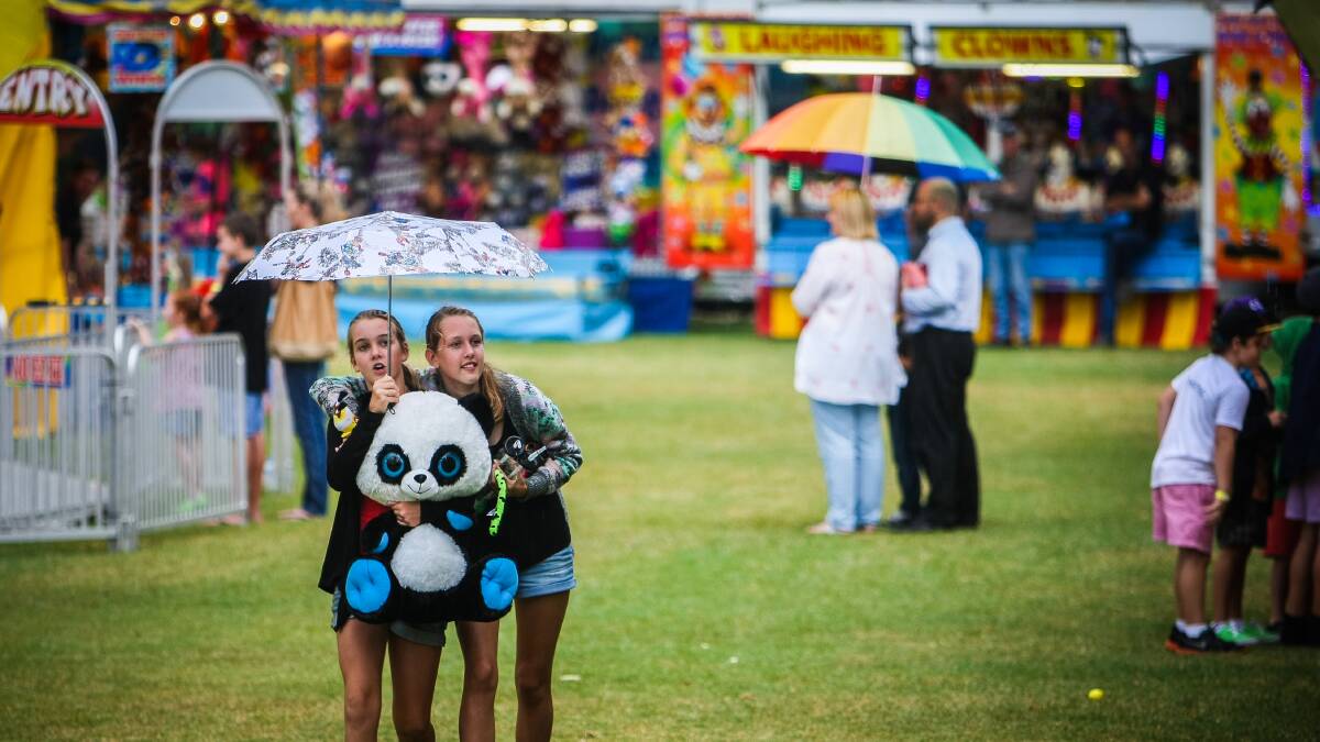 KIAMA: Gerringong's Keeley Doherty and Zoe Cook shelter their prize bear from the rain.  Pictures DYALN ROBINSON