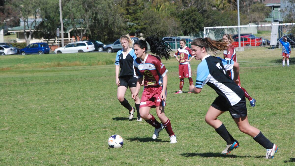 CHARGING FORWARD: Clyde’s Ashleigh Dillon (with ball) looks ahead while Moruya’s Erika Saines (right) hustles into defence. 