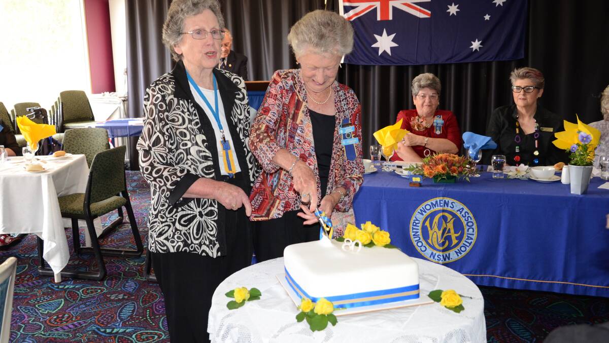 Batemans Bay CWA members Sheena MacDougall and Margaret Mollenburg cut the cake. The pair is also turning 80 this year.