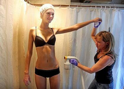 Suzy Righi gives model Grace Holt a spray tan in the lead-up to the L’Oreal Melbourne Fashion Festival. Sunbeds are now taboo in the fashion industry.