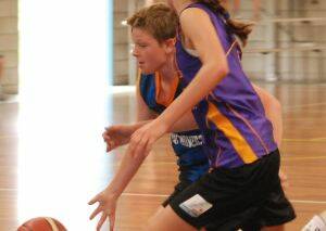 ON THE MOVE:  New Bay Movers player Jarrad Bloomfield tries to get past Cruisebrokers defender Holly Moore in the Moruya Basketball under 12s grand final on Sunday.
