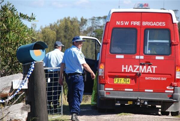 Bodalla police officers assist a NSW Fire Brigade HAZMAT vehicle from Batemans Bay that was involved in the investigations that were carried out at a Bingie residence yesterday.  Photo: SAM GROVES