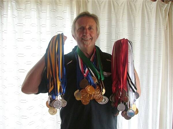 TED’S TALLY:  Batemans Bay Squash Club’s Ted Freeman with just some of the medals he has won competing in squash tournaments around the world.