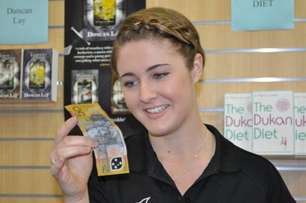 REALITY CHECK:  Angus & Robertson Batemans Bay sales assistant Kathryn Andrew scrutinises a $50 note for authenticity.