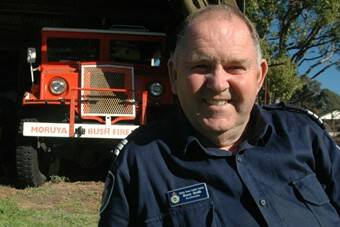 KEEP ON TRUCKIN’: Moruya RFS member and Australian Fire Service Medal recipient Bruce Smith with Moruya’s second oldest, and long decommissioned, fire truck, an ex-army 1942 Chevy Blitz. The service’s oldest truck sleeps peacefully in a neighbour’s paddock.