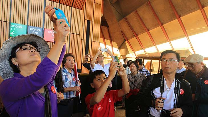 Pay-off at last … Chinese tourists, such as those seen here on a Mandarin tour of the Opera House in Sydney, are being drawn down under by a more China-friendly tourism industry.