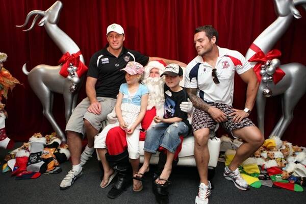 NEW TURF:  Matt Cross (left) in his new Manly colours at the NRL One Community Christmas party, with Annalise Crews, Santa Claus, son Riley Cross and Roosters player Daniel Conn.