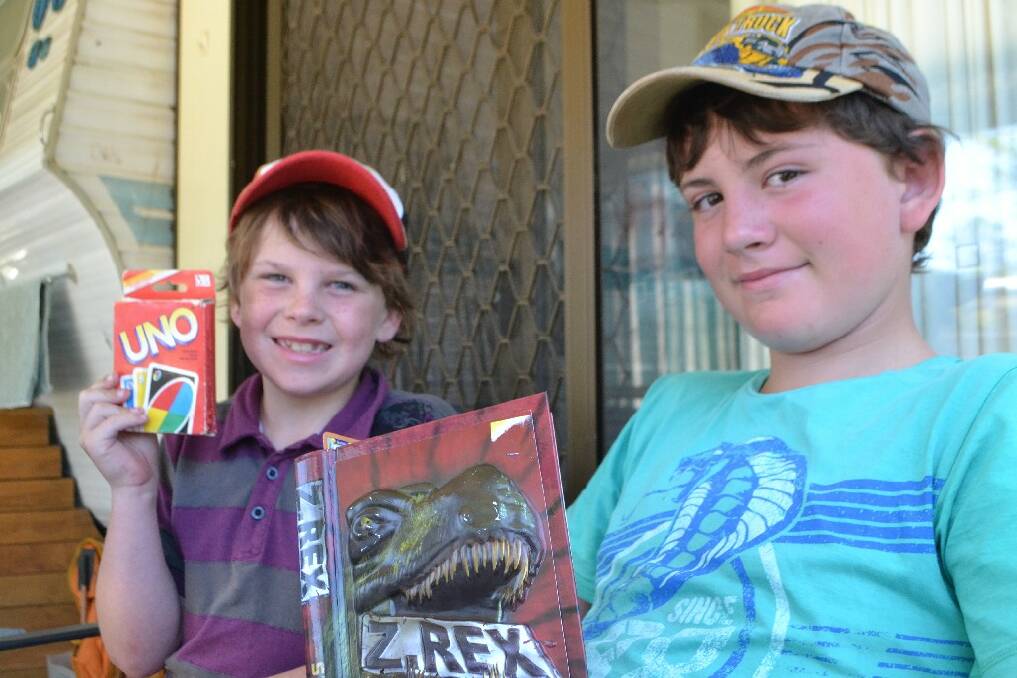 Jacob Carter, 13, of Goulburn enjoys a Christmas book while holidaying at Caseys Beach Holiday Park, while Joshua, 10, intends to remain family Uno champion. They are holidaying with parents Natalie and Jeremy.