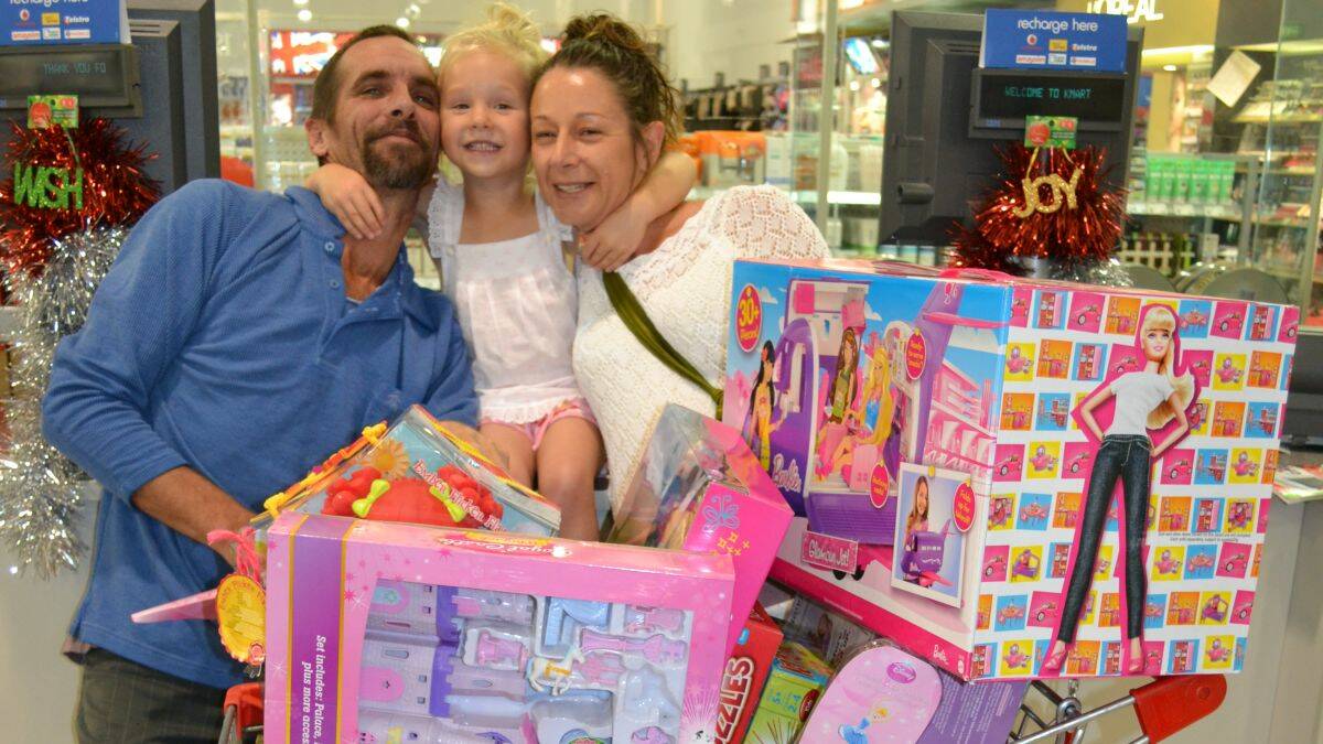 TOY TREAT: Grace McNeilly with dad Steve and mum Joanne and all her loot. The little Moruya girl was facing a bleak Christmas before her name was drawn out in the Bay Post/Moruya Examiner Great Toy Grab.