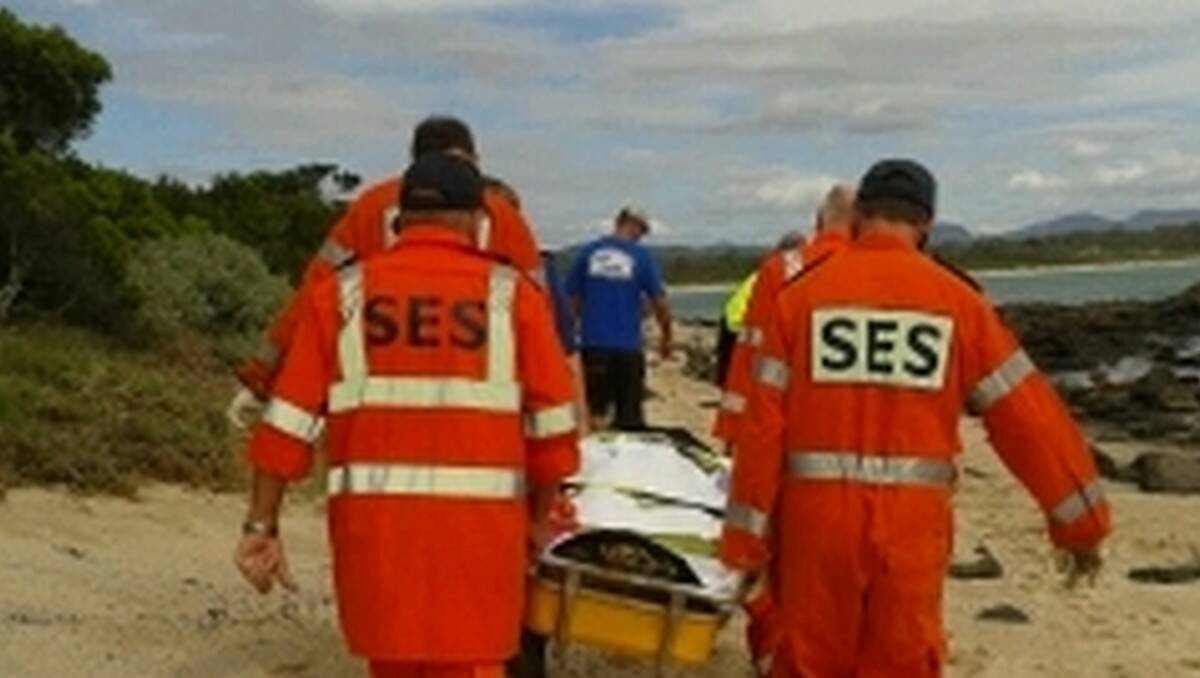 LONG MARCH: SES volunteers carry an injured teen across the sand and rocks at Broulee.