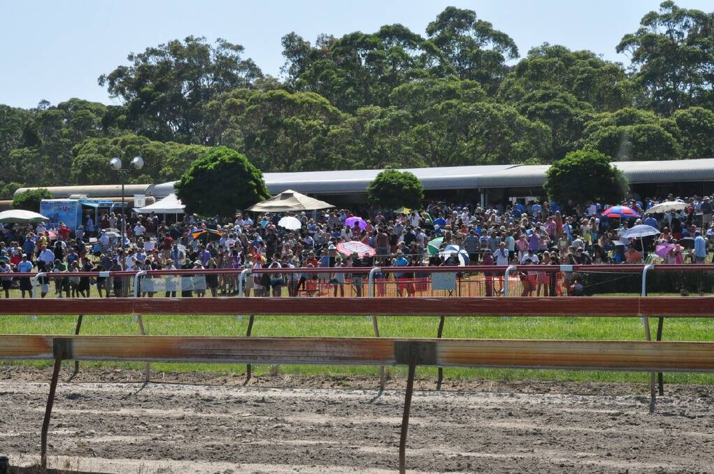 BIG NUMBERS: A section of the record Moruya racecourse crowd enjoys race five on Monday.