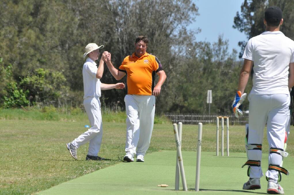 CLEANED UP: Bay Tigers Gold bowler Murray Cooper (orange shirt) celebrates after picking up his first wicket against Tuross Head on Saturday. PHOTO: Dean Benson.
