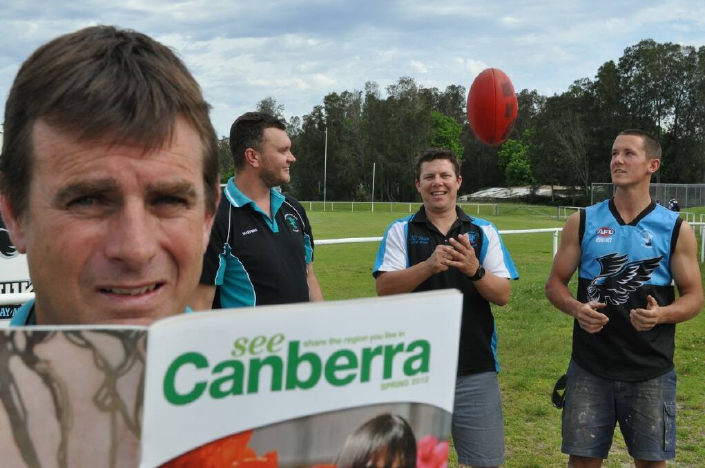 ACT-ING UP: Bay Seahawks president Danny White (left) reads up on the club’s new surroundings as members of the playing group Damon Connick, Dwayne Gentner and Taeg Rosevear celebrate the big announcement at Hanging Rock Oval on Wednesday. PHOTO: Dean Benson.