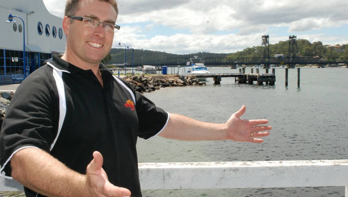 OPEN ARMS: Batemans Bay Chamber of Commerce’s Darren Knight is ready to welcome the MS Caledonian Sky’s passengers to Batemans Bay.