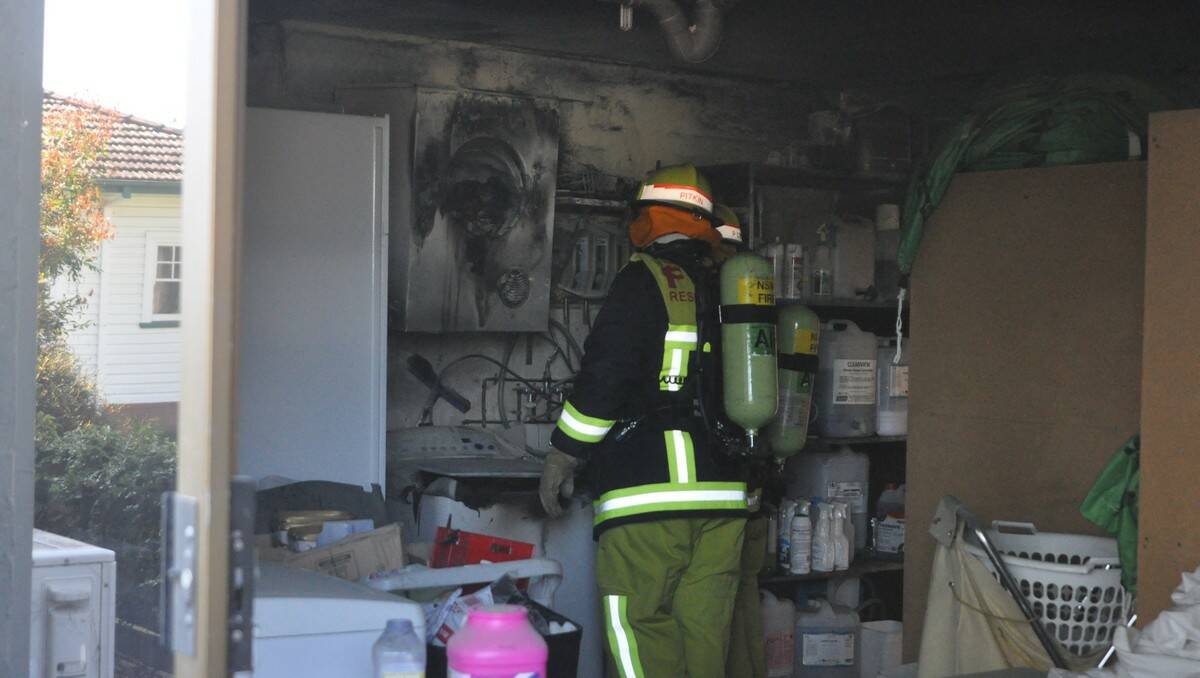 Batemans Bay Fire and Rescue crew inspect the damage a fire caused in the motel's laundry room.